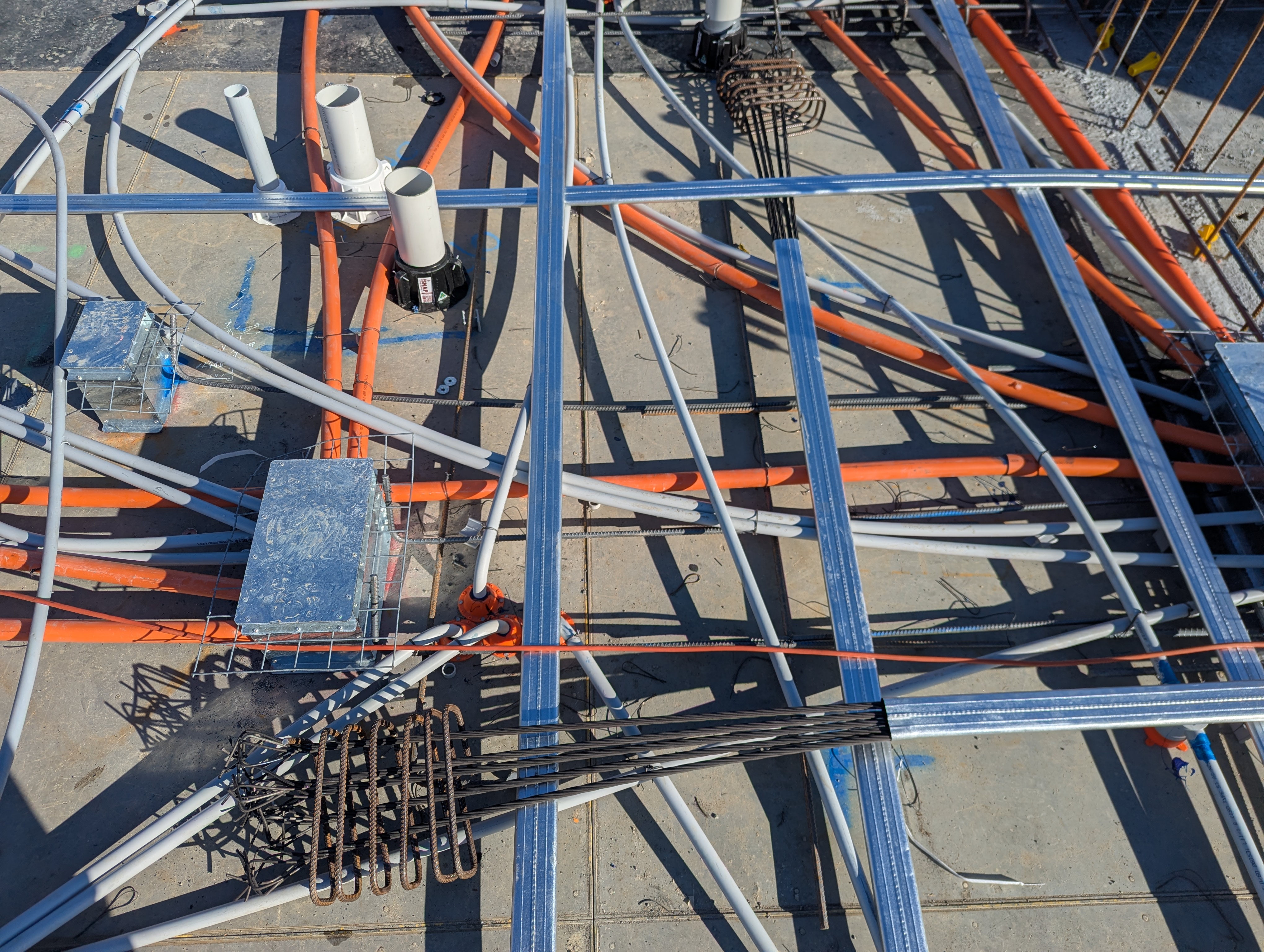 Pre-pour structural slab showing reinforcement and conduits before concrete is poured